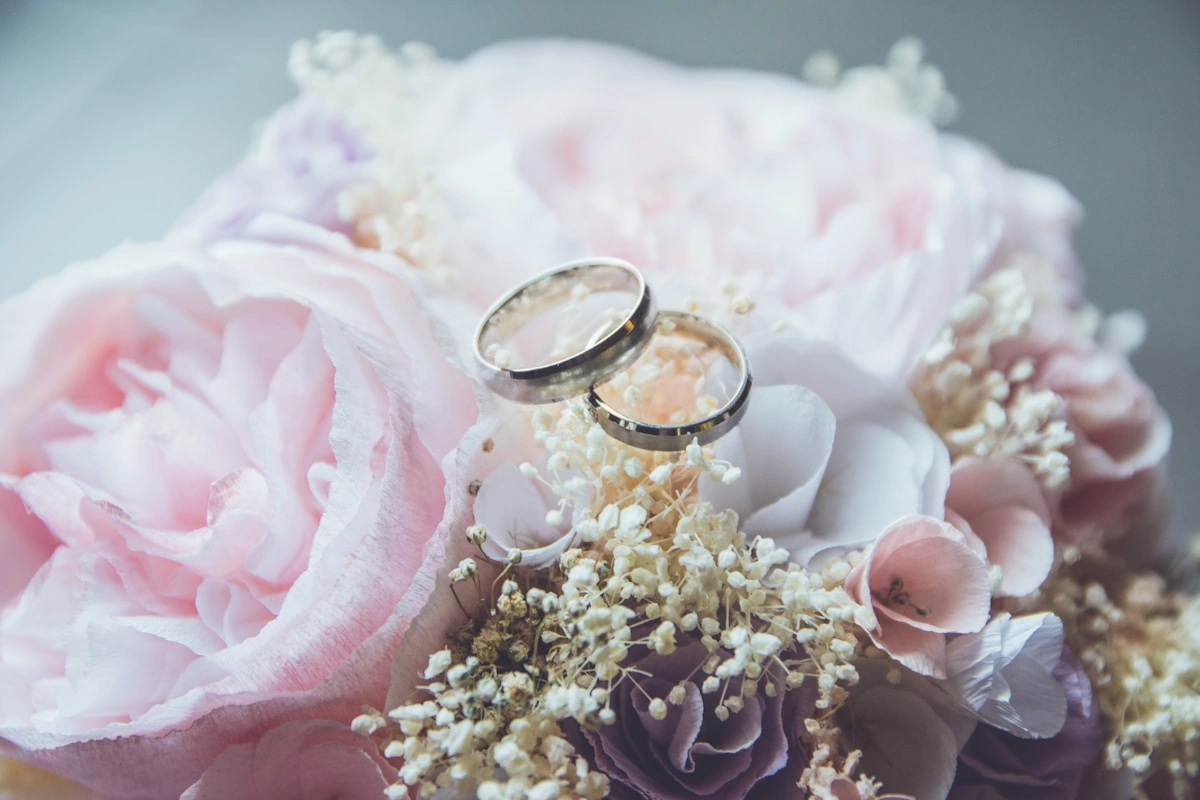 Detalle de argollas y ramo de boda